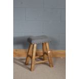 Stripped pine stool, with grey stud work upholstery, raised on four block legs, 51cm high