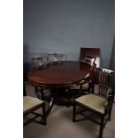 Mahogany twin pillar dining table, raised on claw feet, together with four Sheraton style dining