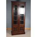 Early 20th century oak bookcase, having half roundels and geometric decoration above a pair of