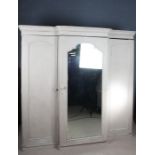 Victorian painted triple wardrobe with mirrored centre door, opening to reveal four shelves above