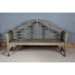 Lutyens style garden bench, having shaped back and spindled scrolling armrests, after a design by