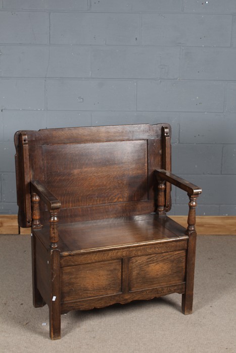 20th century oak monks bench, the sliding and falling top above a lidded storage compartment, with