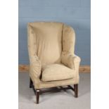 18th century style wing back armchair, having high back rest and raised on tapering block legs and