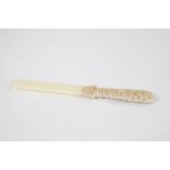 Late 19th Century ivory page turner, the foliate carved handle above a carved basket containing