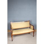 Edwardian inlaid mahogany two seater settee, the padded back with a crested rail above open arms,