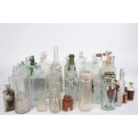 Large collection of clear and green glass apothecary and other bottles, housed within a wooden