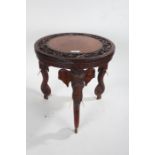 African carved hardwood elephant table, the circular top carved in relief with a border of scrolling