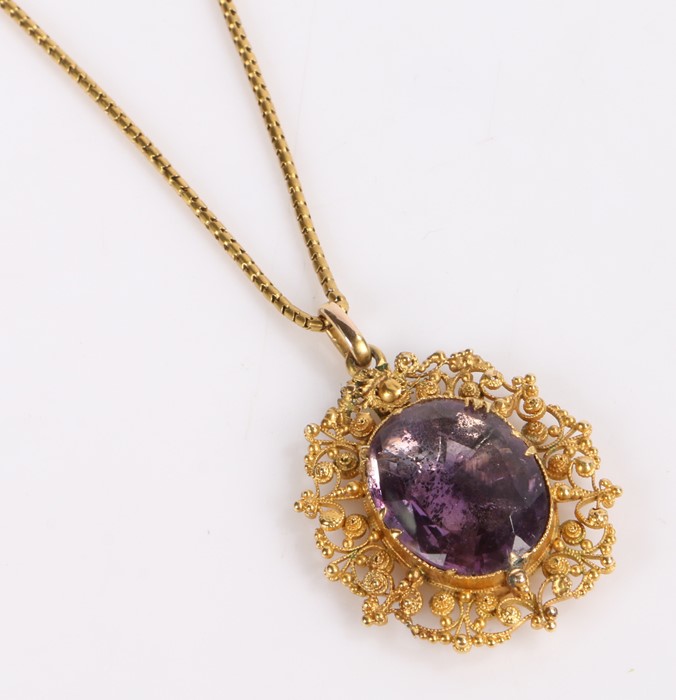 Victorian amethyst set pendant, on a yellow metal mount with scroll design together with a yellow