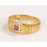 Ruby and diamond set ring, the central square cut ruby with a fourteen diamond surround, ring size