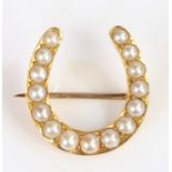 Edwardian pearl set horseshoe brooch, with a row of graduated pearls to the horseshoe, 22mm
