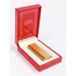Cartier gold plated cigarette lighter, with engine turned banded exterior, 7.5cm high, housed in a
