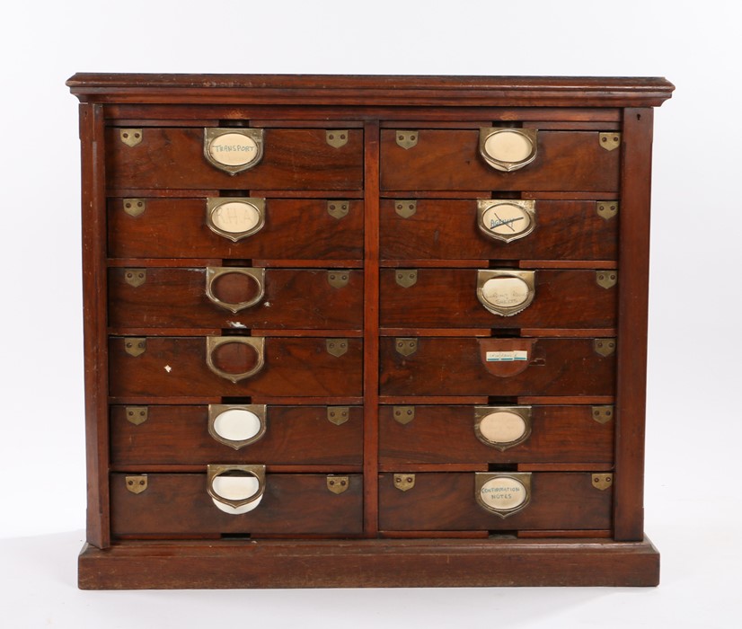 Edwardian dark stained bank of twelve drawers, with side locking bars flanking the drawers, raised
