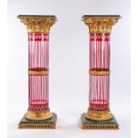 Pair of ruby and clear glass marble and gilt metal mounted columns, the green marble tops with