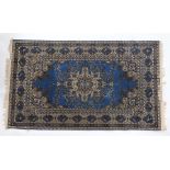Machine made Persian design rug. The blue ground with foliate centre surrounded by a bird