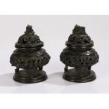 Two Japanese bronze pots and covers, with a dome top above the rounded squat body raised in legs, (