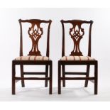 Pair of George III mahogany chairs, with an undulating top rail above the shaped splat and drop in