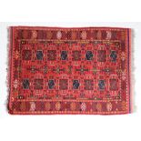 Modern Afghan rug, the red ground with elephant foot lozenge pattern centre and tasselled ends,