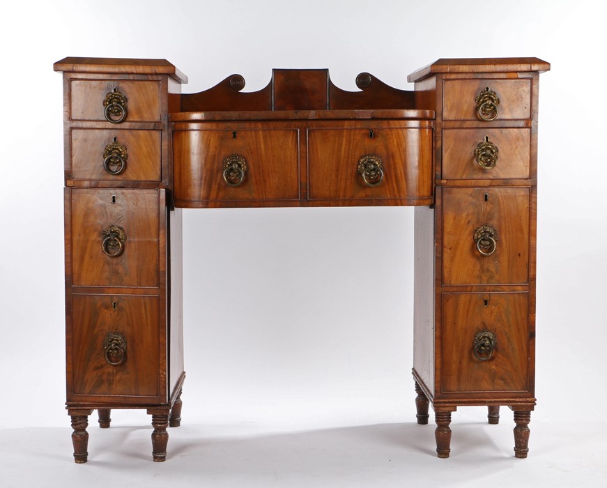 Victorian mahogany sideboard, the roundel carved upstand flanked pedestals each containing two small