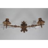 Ornate cast brass twin branch candle sconce, having beast mask motif