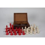 20th century bone chess set. with stained red pieces, housed within an oak box (32 pieces)