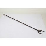 19th Century steel fire poker, of long proportions, with a knob finial, with a two prong end,