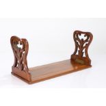 Victorian walnut sliding bookrack, with fret carved ends, 33cm wide when closed