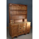 Early 20th Century pine dresser, the plate rack with three shelves and four drawers, the dresser