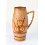 Art Deco Delwood pottery vase, with brightly coloured flowers on a light brown ground, with carrying