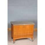 20th century teak cocktail cabinet, having sliding top, the drop front enclosing an interior for