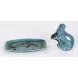 Poole pottery otter, modelled holding a fish, 11cm high, together with a Poole dish decorated with a