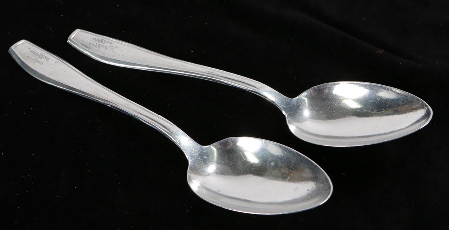 A pair of aluminium table spoons, engraved with 'SS' runes on the handle and stamped 'Aluminium'