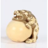 Japanese Edo period ivory Netsuke, carved as Shishi clutching a ball, unsigned, 32mm high