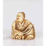 Japanese Edo period ivory netsuke, carved as a man with folded legs holding his Juzu beads,