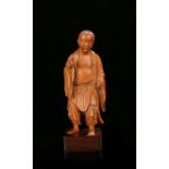 Chinese boxwood figure, Qing Dynasty, the standing figure carved with a smile, left hand raised with