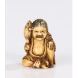 Japanese Edo period ivory netsuke, carved as a figure resting on his leg holding a toad up to his