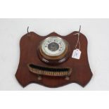 Edwardian mahogany wall hanging brush rack, with central barometer, curved brush and hooks for a