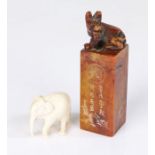 Soapstone opium weight mounted by a bear above incised decorations and character marks, 8.5cm