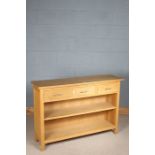 Light oak sideboard, the rectangular top with three frieze drawers, above an open shelf, raised on