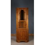Pine corner cupboard, the top with a glazed door and an open gallery, the base with a hinged door,