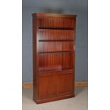 Mahogany open bookcase, the dentil pediment above three adjustable shelves, the base with two