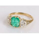 Emerald and diamond set gold ring, the central 1.7ct emerald flanked by two 0.85ct diamonds, ring