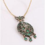 Emerald and diamond set pendant, the tied ribbon pediment above an oval body set with emeralds and