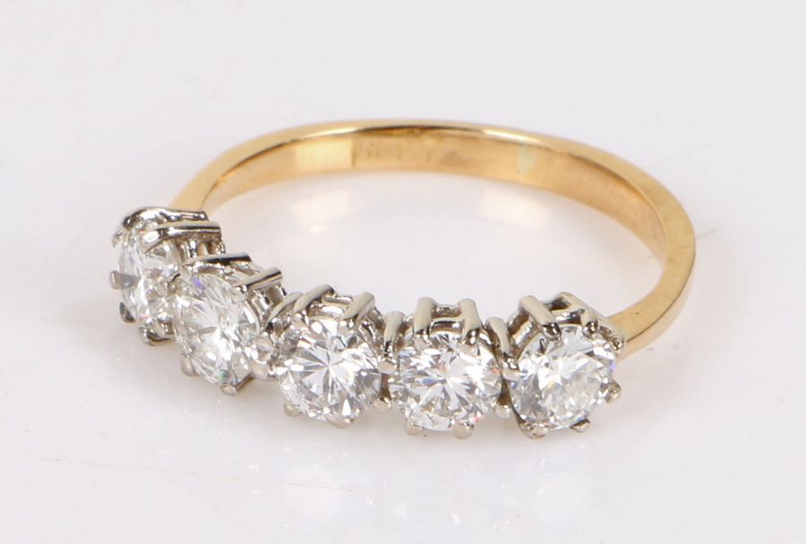 18 carat gold diamond set ring, with a row of five round cut diamonds totallign an estimated 1.55