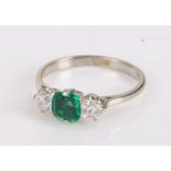 Emerald and diamond set ring, the central emerald at an estimated 0.33 carats flanked by a diamond