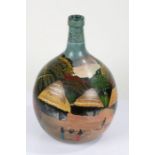 Nigerian painted green glass demijohn, decorated with houses in a forest, with figures besides a