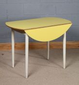 Mid 20th Century formica drop leaf table, the circular top in yellow, above turned tapering legs,