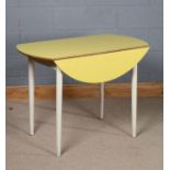 Mid 20th Century formica drop leaf table, the circular top in yellow, above turned tapering legs,