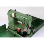 Elna sewing machine, in green, housed within a metal carrying case (sold as collectors item)