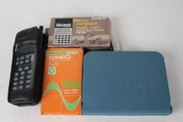 Casio fx-115 boxed calculator, Philips PR143 mobile phone, Casio CM-100 boxed calculator, and a