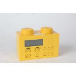 Lego portable clock radio, in the form of a yellow brick, with charger, 16cm wide and 11.5cm high